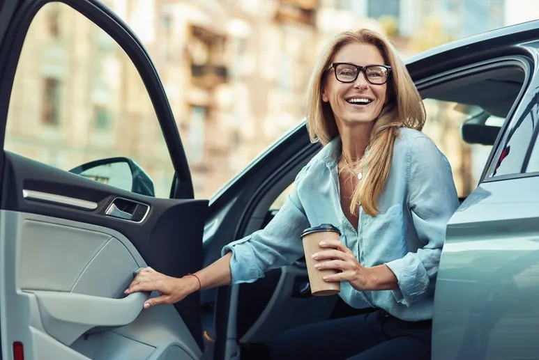 Collega stapt met een kop koffie in een gedeelde leaseauto - de spelregels van het delen